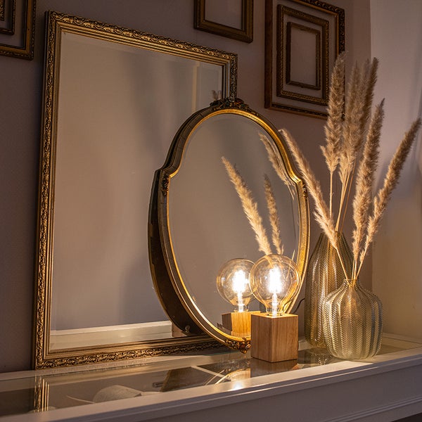 Dekorative Szene mit Spiegeln, Lampe und Vase auf einem Tisch