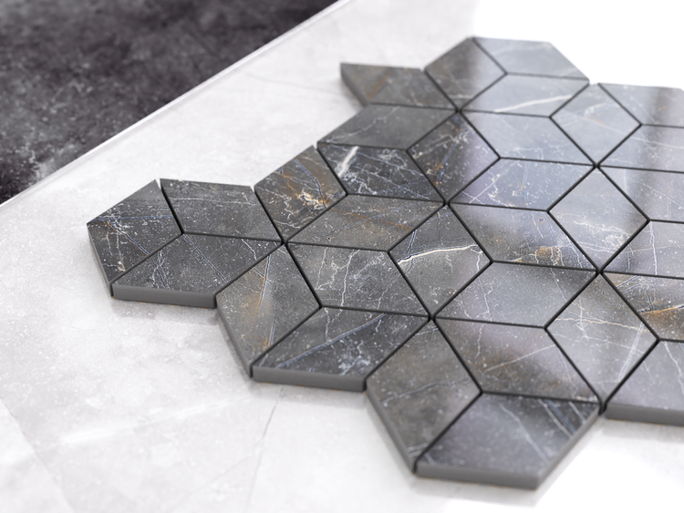 Mosaikfliesen in Marmoroptik mit Rautenmuster in Dunkelgrau auf einer hellen Bodenfliese.