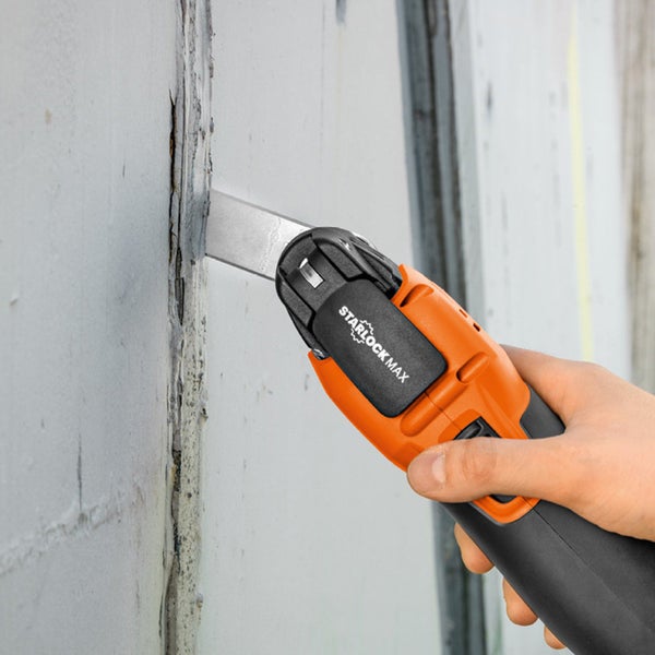 Handwerker verwendet Multifunktionswerkzeug zum Entfernen von Material von einer Wand