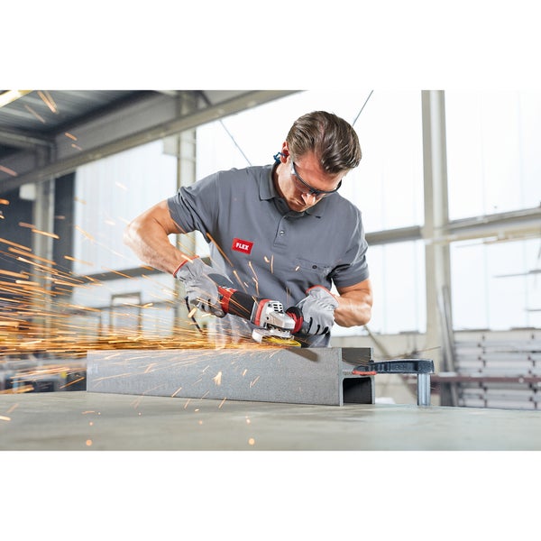 Handwerker mit Schutzbrille und Handschuhen bearbeitet einen Stahlträger mit einem Winkelschleifer von Flex, wobei Funken fliegen.