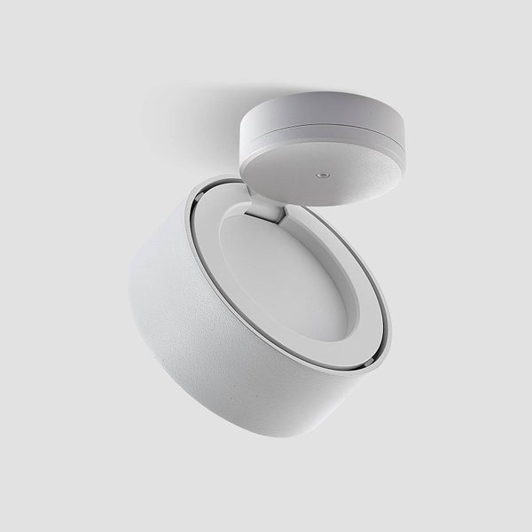 Schwenkbarer runder Aufbaustrahler aus weißem Metall mit matter Oberfläche.