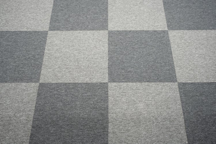 Teppichfliesen mit Schachbrettmuster in hellen und dunklen Grautönen.
