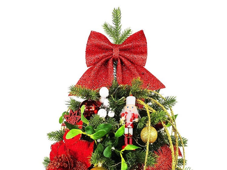 Weihnachtsbaumspitze mit einer großen Schleife dekoriert, ergänzt durch Ornamente wie einen Nussknacker und Kugeln.