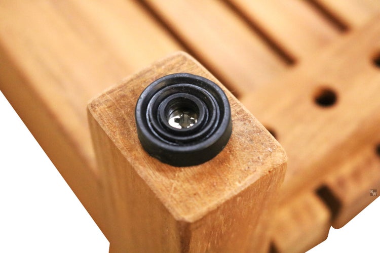 Detailansicht eines schwarzen Fußes an einem Holzmöbelstück