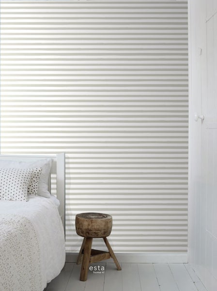 Raum mit gestreifter Tapete, Bett und Holzhocker