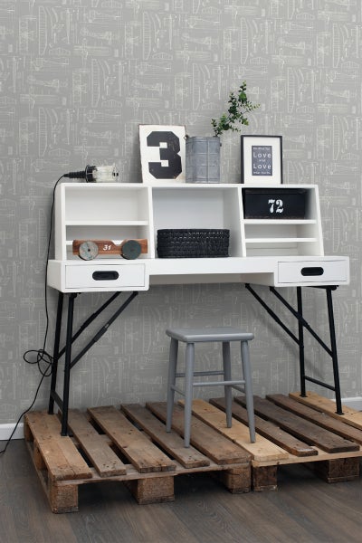 Weißer Schreibtisch mit schwarzem Metallgestell und grauem Hocker auf Holzpaletten
