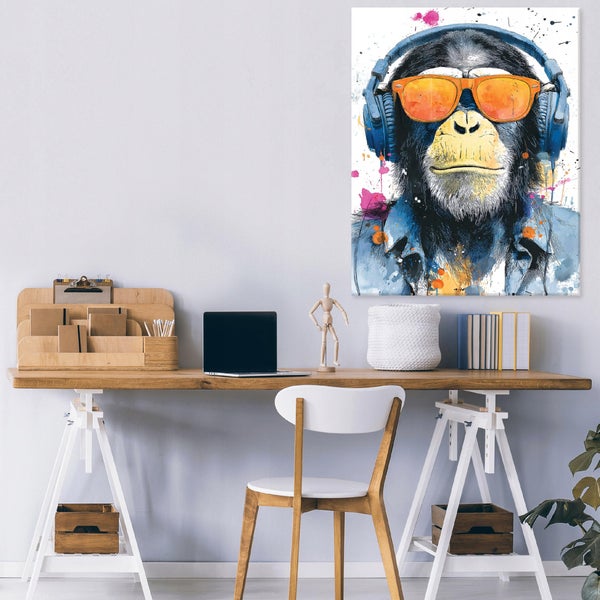 Wandbild mit künstlerischer Darstellung eines Affen mit Kopfhörern und Sonnenbrille über einem modernen Schreibtisch mit Laptop und Zubehör.