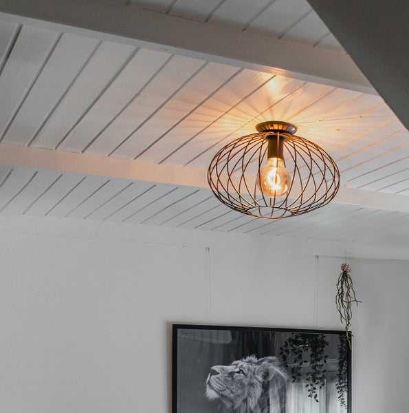 Deckenleuchte mit Metallgestell und Glühbirne in einem Wohnraum