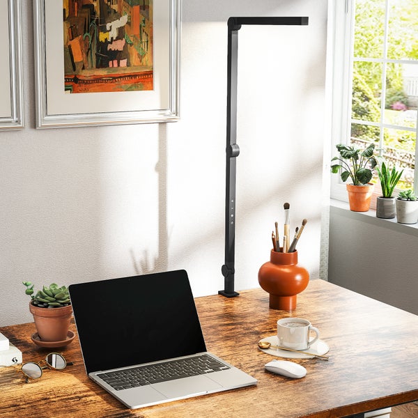 Arbeitszimmer mit Schreibtisch, Laptop, Stehlampe und Dekoration
