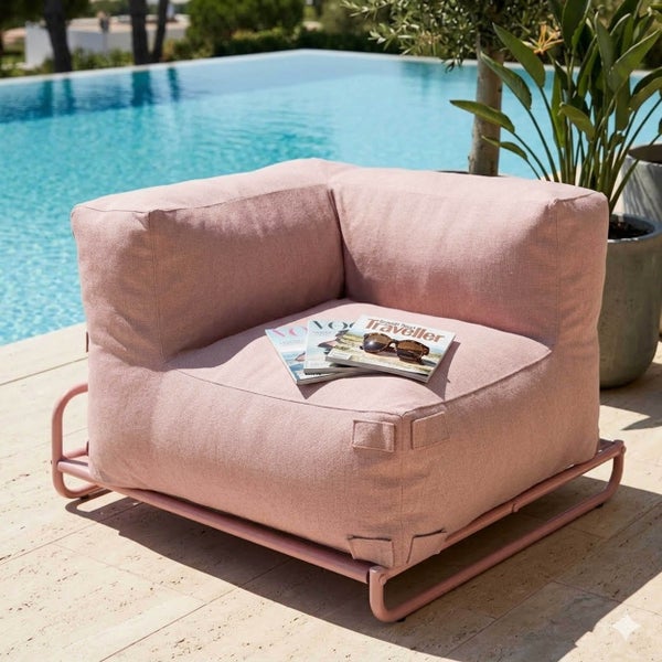 Rosa gepolstertes Garten-Lounge-Modul mit Metallgestell auf einer Steinterrasse neben einem Pool.