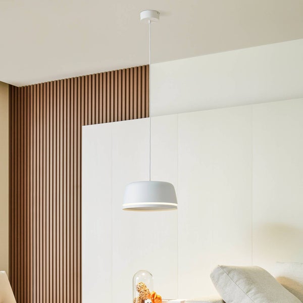 Moderne weiße Pendelleuchte mit kuppelförmigem Schirm in hellem Wohnzimmer mit Wandpaneelen und Akzentwand aus braunen Holzlamellen.