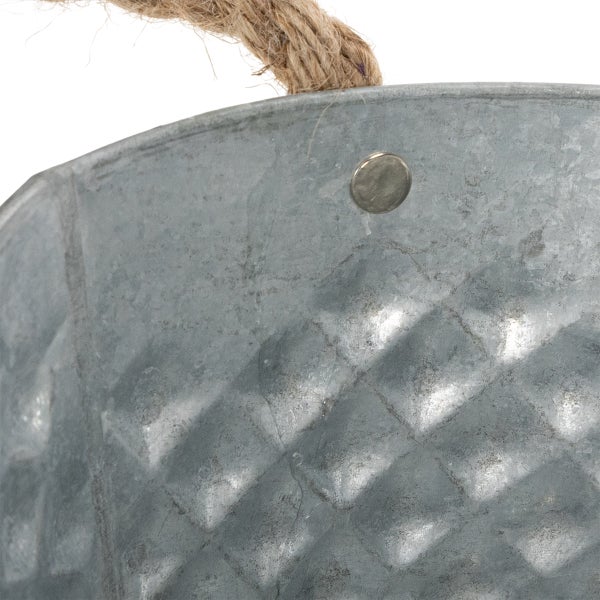 Detailaufnahme eines Zinkeimers mit geprägtem Rautenmuster und einem Griff aus Seil.