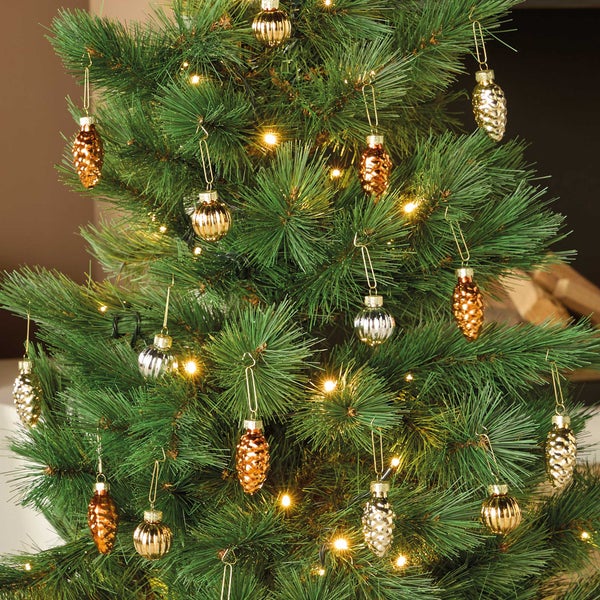 Weihnachtsbaum mit künstlichen Tannenzweigen geschmückt mit verschiedenen glänzenden Weihnachtsbaumkugeln in Form von Zapfen und Kugeln
