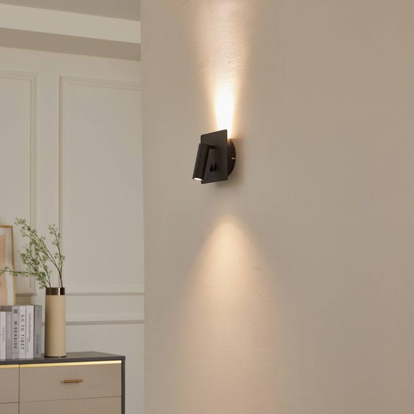 Moderne schwarze Wandleuchte mit verstellbarem Spot an einer hellen Wand, Lichteffekt nach oben und unten, minimalistisches Design.