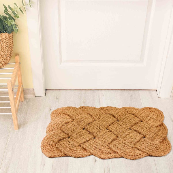 Geflochtener Fußabtreter aus Naturfaser vor einer Tür