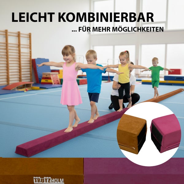 Mädchen trägt einen pinken Gymnastik-Schwebebalken aus EVA-Schaum mit Vlies-Überzug, hautfreundlich und gelenkschonend, Gewicht circa 2,6 Kilogramm.