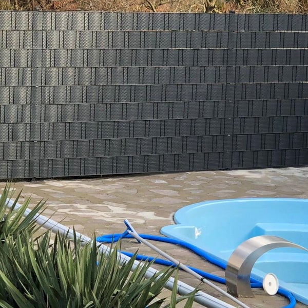 Grauer Sichtschutzzaun aus Kunststoff neben einem Schwimmbecken