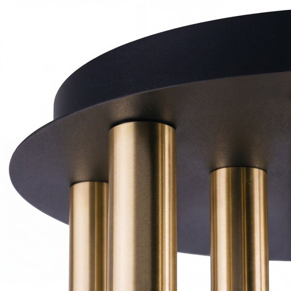 Nahaufnahme einer modernen Deckenleuchte mit schwarzer Halterung und goldfarbenen Metallzylindern.