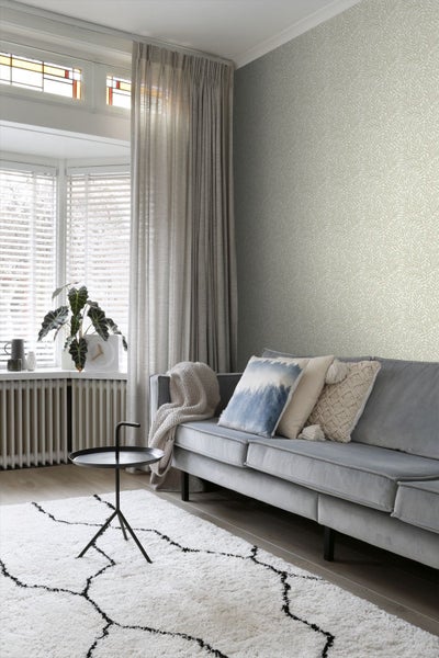 Wohnzimmer mit Sofa, Teppich und gemusterter Tapete