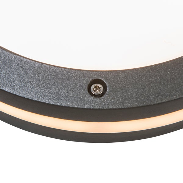 Detailansicht einer runden Wandleuchte mit strukturiertem Rahmen, Innensechskantschraube und leuchtendem Lichtring.