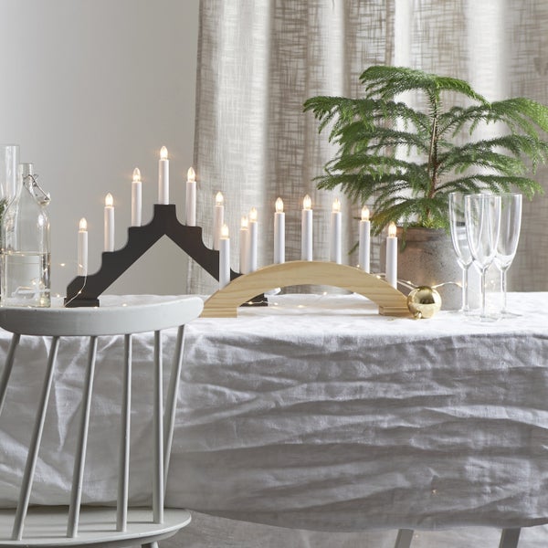 Dekorativer Lichterbogen aus Holz mit Kerzen auf einem Tisch