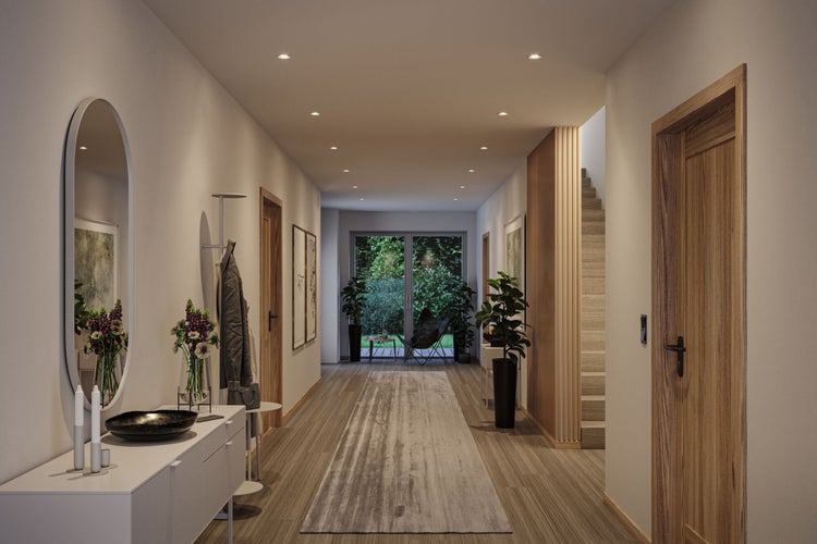 Heller, moderner Flur mit Holztüren, einem ovalen Spiegel, weißem Sideboard und Holzfußboden. Am Ende führt eine Glastür in den Garten.