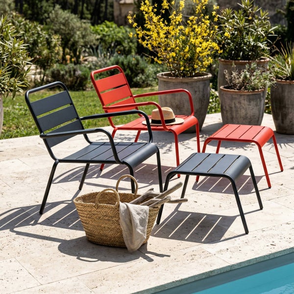 Moderne Garten-Loungesessel und Hocker aus Metall in Grau und Rot auf einer Terrasse am Pool mit Pflanzen.