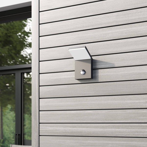 Moderne LED-Außenwandleuchte in Anthrazit mit Bewegungsmelder an einer Fassade aus Holzpaneelen montiert.
