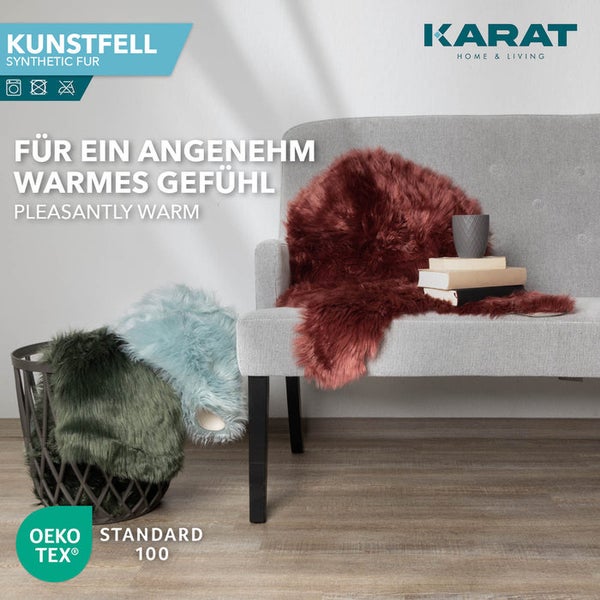 Karat Home & Living Logo, Kunstfell auf Sofa und in Korb in gemütlichem Wohnzimmer, OEKO-TEX Standard 100 für schadstoffgeprüfte Textilien.