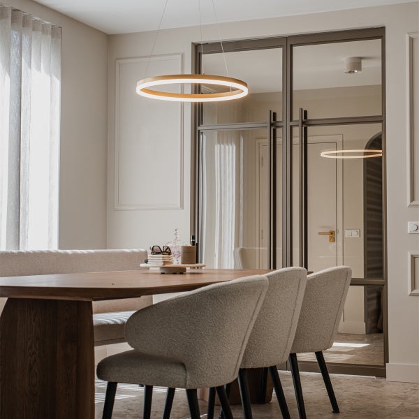 Esszimmer mit Esstisch, Stühlen und ringförmiger Hängelampe
