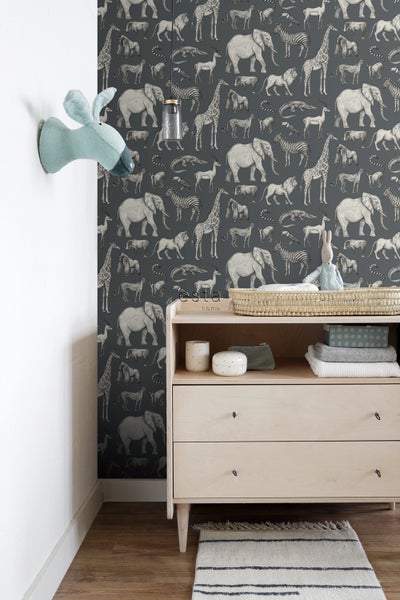 Kinderzimmer mit Tiermuster-Tapete, Kommode, Wanddekoration und Teppich
