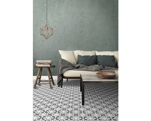 Wohnzimmer mit Sofa, Tisch, Hocker, Pendelleuchte und gemusterten Bodenfliesen