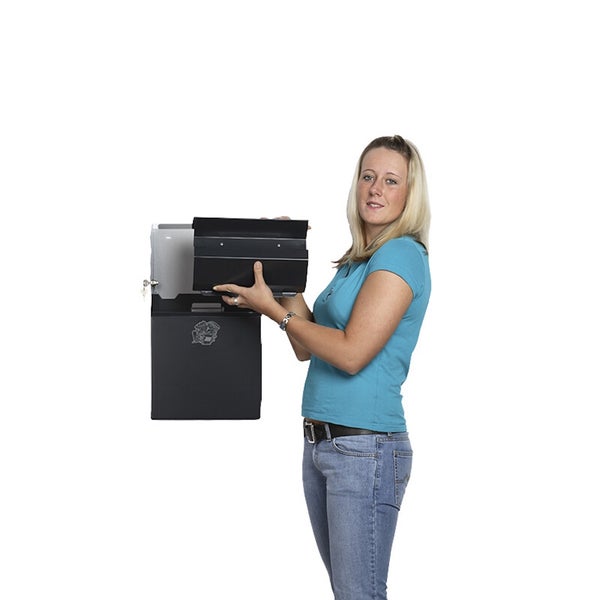 Eine Frau hält einen schwarzen Briefkasten aus Metall und zeigt die geöffnete Einwurfklappe.