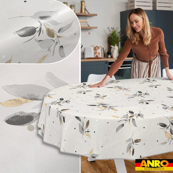 Frau breitet eine runde Wachstuchtischdecke mit Blättermuster in einer hellen Küche aus, Detailansicht der Struktur und ANRO Logo.