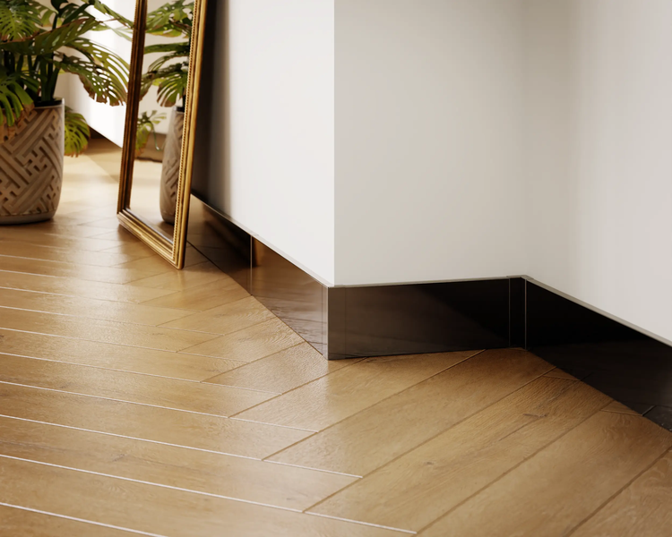 Zimmer mit Holzboden, weißen Wänden und dunklen Sockelleisten.