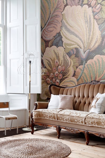 Wohnzimmer mit Sofa, Stehlampe und floraler Tapete