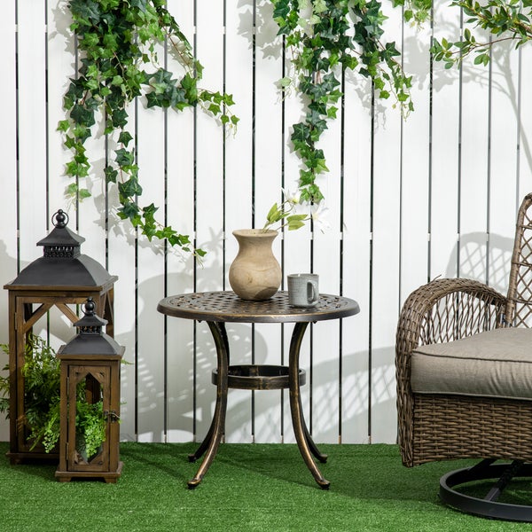 Detailansicht einer runden Garten-Tischplatte aus Metall mit dekorativem Gittermuster und Verzierungen im antiken Stil.