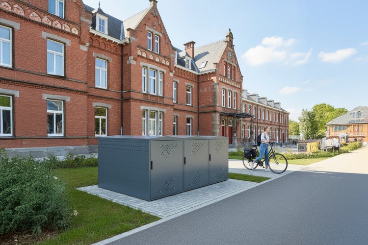 Fahrradgarage vor einem Backsteingebäude mit einer Frau auf einem Fahrrad