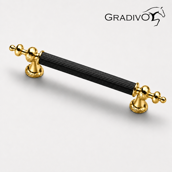 Möbelgriff mit schwarzem, geriffeltem Mittelteil und goldfarbenen, verzierten Endstücken. Gradivo Logo.