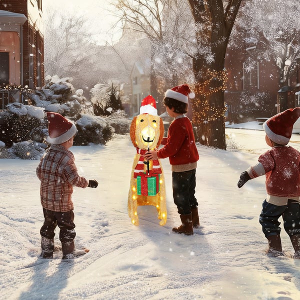 Kinder im Schnee neben einer beleuchteten LED Weihnachtsfigur in Form eines Hundes mit Weihnachtsmütze und Geschenk.