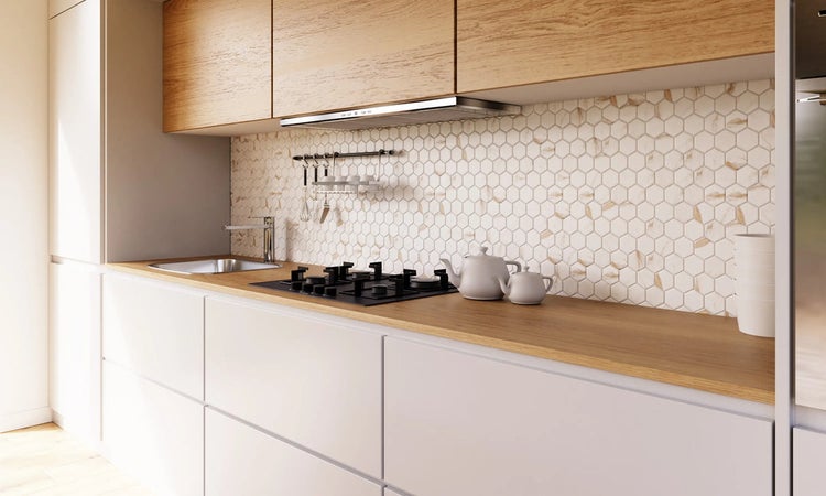 Helle Küche mit Spüle, Kochfeld, Dunstabzugshaube und hexagonförmigen Fliesen