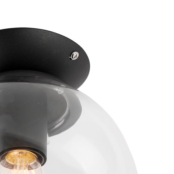 Detailansicht einer Deckenleuchte mit Klarglas-Schirm und schwarzer Deckenbefestigung.