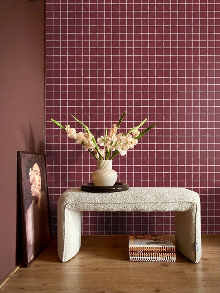 Raumansicht mit karierter Wand, Bank, Vase mit Blumen und Bild