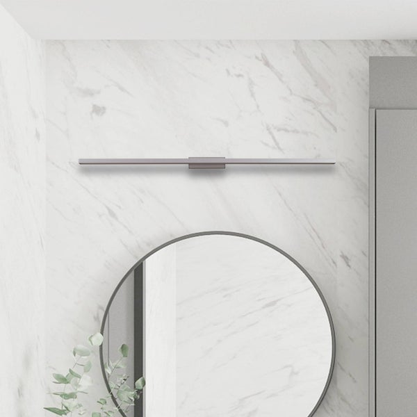 Moderne, lineare LED-Spiegelleuchte über einem runden Wandspiegel an einer Marmorwand im Badezimmer.