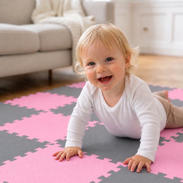 Ein Kleinkind krabbelt auf einer gepuzzelten Spielmatte aus Schaumstoff im Wohnzimmer.