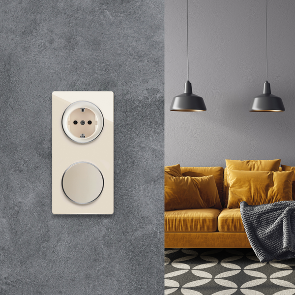 Moderne Steckdosenkombination mit Schalter an einer Betonwand im Wohnzimmer mit Sofa und Hängelampen.