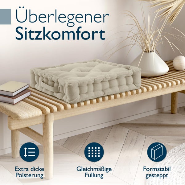 Dekoratives beiges Sitzkissen auf einer Holzbank