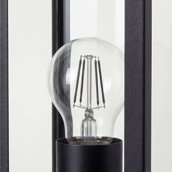 Klare LED-Filament-Glühbirne in einer modernen schwarzen Leuchte mit Glaseinsätzen.