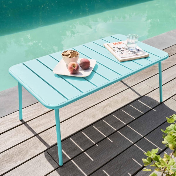 Hellblauer Loungetisch aus Metall mit Lattenstruktur auf einer Holzterrasse am Pool, helles und sommerliches Ambiente.