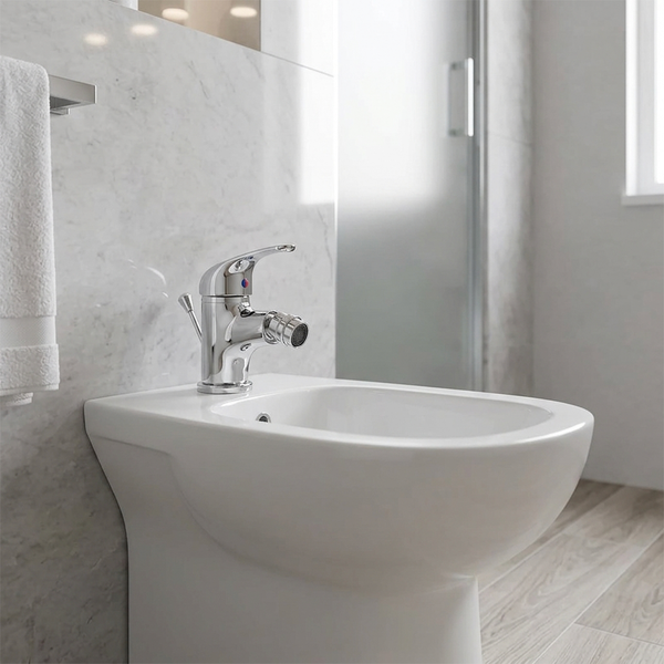 Stand-Bidet aus Keramik mit Einhebel-Bidetarmatur in einem hellen Badezimmer mit Marmorwand und Boden in Holzoptik.